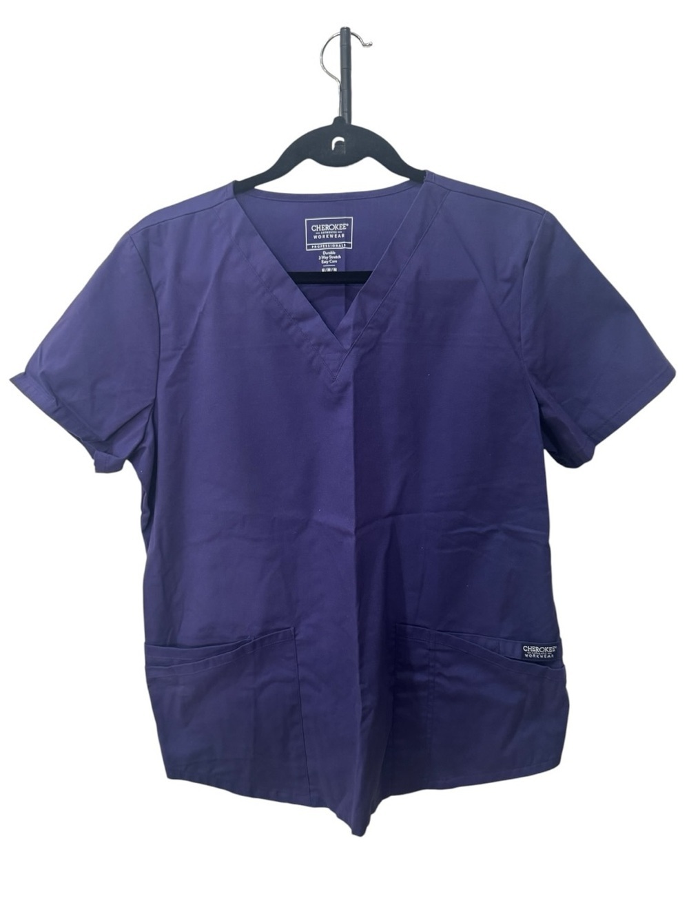 Cherokee Workwear V-neck scrub top is shown in a grape purple women size M